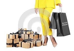 Woman with shopping bags and gift boxes on white background, closeup. Black Friday Sale