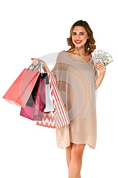 Woman with shopping bags holding money dollars on white isolated background.