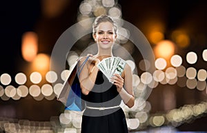 Woman with shopping bags and money at christmas
