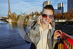 Woman with shopping bags talking on cell phone near Eiffel tower