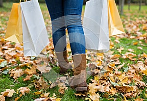 Woman with shopping bags walking along autumn park