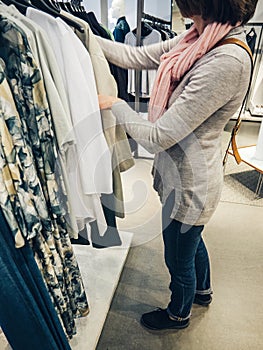 Woman shopping for beautiful modern clothes in casual store