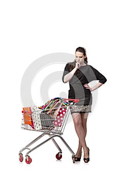 The woman with shopping cart and bags isolated on white