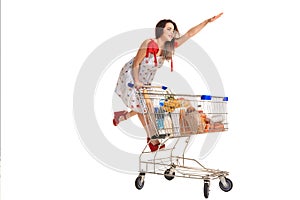 Woman with shopping cart full with products isolated over white background