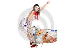 Woman with shopping cart full with products isolated over white background