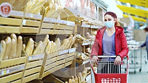 Woman with shopping cart posing near bread shelves during pandemic