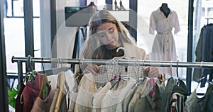 Woman, shopping and clothes in boutique shop, unhappy shopper and looking for outfit. Fashion, clothing store and