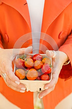 Woman shopping for fresh vegetables produce at a farmers market.