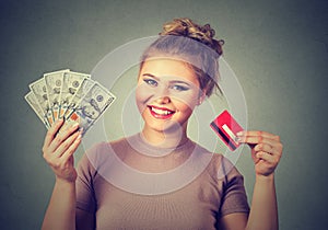 Woman shopping holding showing credit card and cash dollar banknotes bills