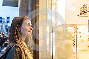 Woman shopping in London and looking at a shop window