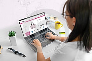 Woman shopping online concept. Laptop with modern ecommerce website on display