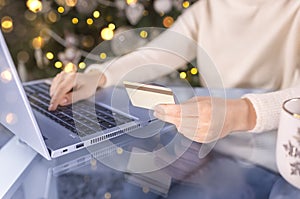 Woman shopping online with laptop at christmas at home in the living room