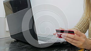 Woman shopping online at laptop with credit card