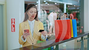 Woman is shopping online on the mall. Credit card in hand of girl. Woman is paying bills. Purchase online by credit card