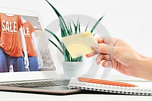 Woman shopping online sale holding gold credit card in a hand