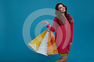 Woman Shopping. Smiling Beautiful Fashion Model With Paper Bags