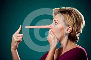 Woman touching her long nose because of lie . People,lifestyle and emotions concept photo