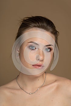 Woman with short hair and bare shoulders erotically looks into the lens, lips slightly parted, nose pierced, earplug