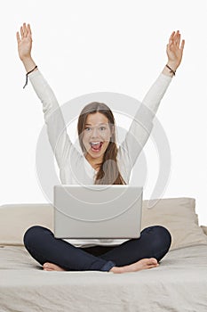 Woman shouting in excitement while working on a laptop