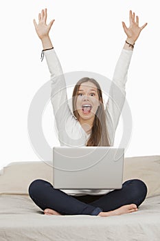 Woman shouting in excitement while working on a laptop