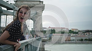 Woman is shouting jokingly on bridge in Budapest