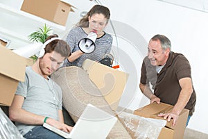 Woman shouting through loudhailer at man wearing headphones photo