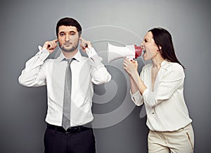 Woman shouting in megaphone at the calm man