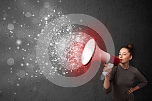 Woman shouting into megaphone and glowing energy particles explode