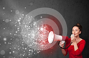 Woman shouting into megaphone and glowing energy particles explode