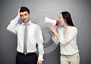 Woman shouting in megaphone at the tired man