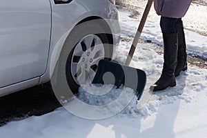 Woman shoveling here parking lot after a winter snowstorm