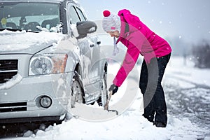 Woman shoveling snow from her car