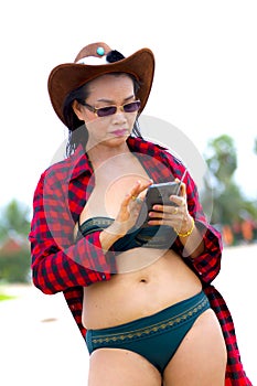 Woman show bikini and red greatcoat on beach photo