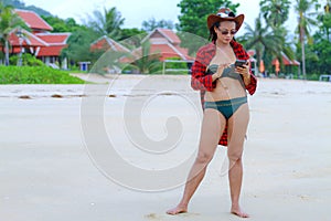 Woman show red greatcoat and bikini on beach photo