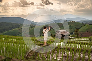 The woman is show victory sign on the rice field At papong pian house, Chiangmai,Thailand