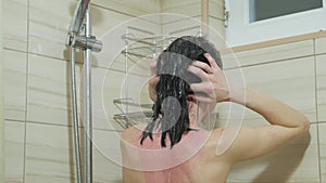 Woman in the shower, back side of young female showering under refreshing water, healthy lifestyle. Girl washing long