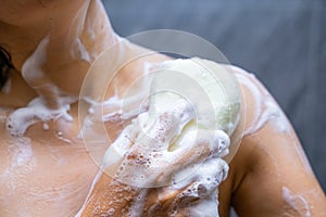 Woman shower with body scrub sponge