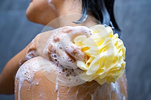 Woman shower with body scrub sponge