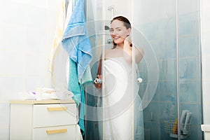 Woman showering in shower cabin cubicle.