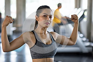 woman showing arm muscle in gym