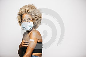 Woman showing the band-aid on her arm after vaccination