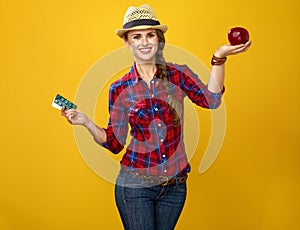 Woman showing benefits of healthy food as opposed to medicine