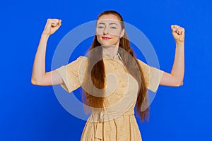 Woman showing biceps and looking confident, feeling power strength to fight for rights, success win