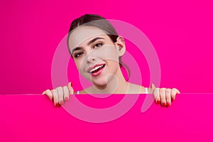 Woman showing blank signboard. Girl holding a blank paper isolated background. Sheet of paper in hands. Copy space