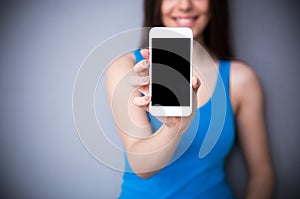 Woman showing blank smartphone screen. Focus on smartphone