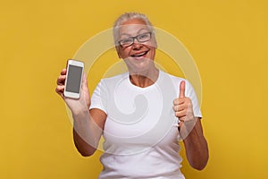 Woman showing blank smartphone screen and thumb up approving your choice