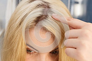 Woman showing blonde hair roots