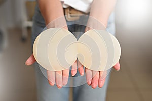 Woman showing breast augmentation implants in her hands