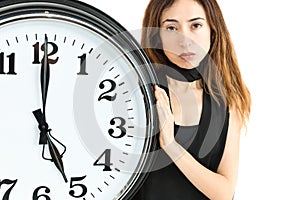 Woman showing clock with a tired expression