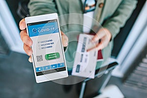 Woman showing covid passport on the smartphone at an airport control